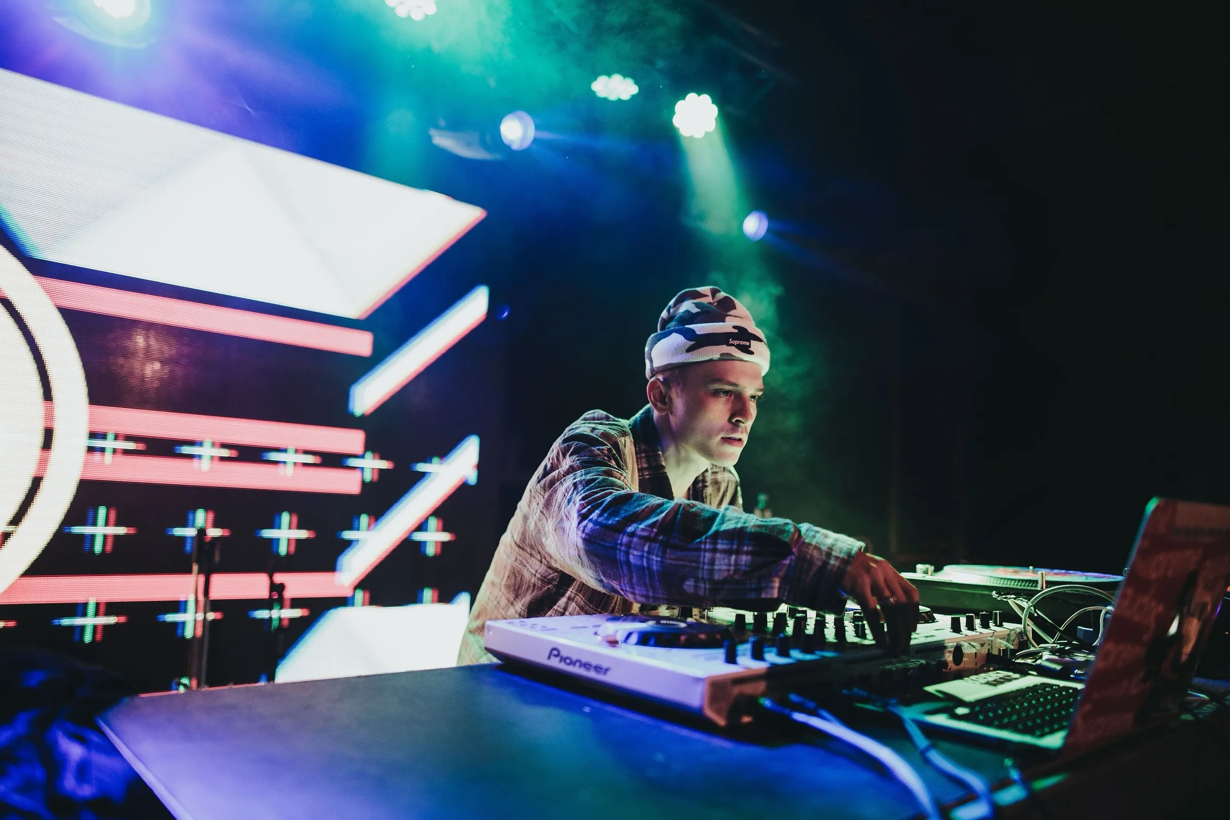 DJ tocando em uma festa com luzes coloridas